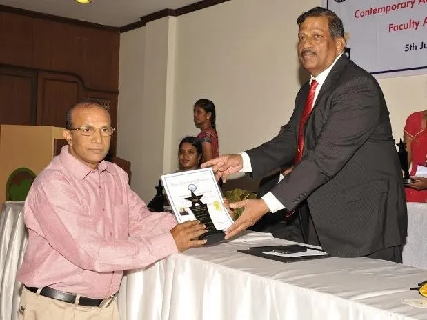 Dr. Joseph S. Thekedam receiving the Outstanding Faculty Award from VIFFA